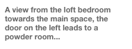 A view from the loft bedroom towards the main space, the door on the left leads to a powder room...